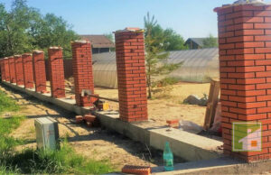 Как выбрать оптимальный фундамент для забора с кирпичными столбами