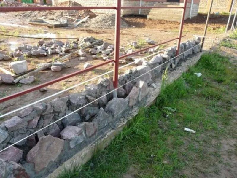 Как выбрать оптимальный фундамент для забора с кирпичными столбами